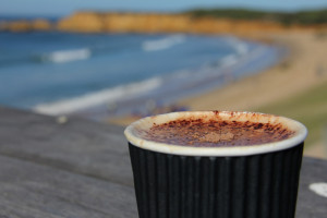 Take away coffee with cliffs and coast in the background